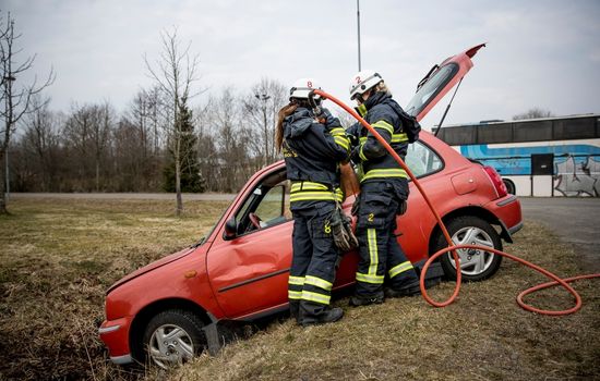två brandman som arbetar vid en bil